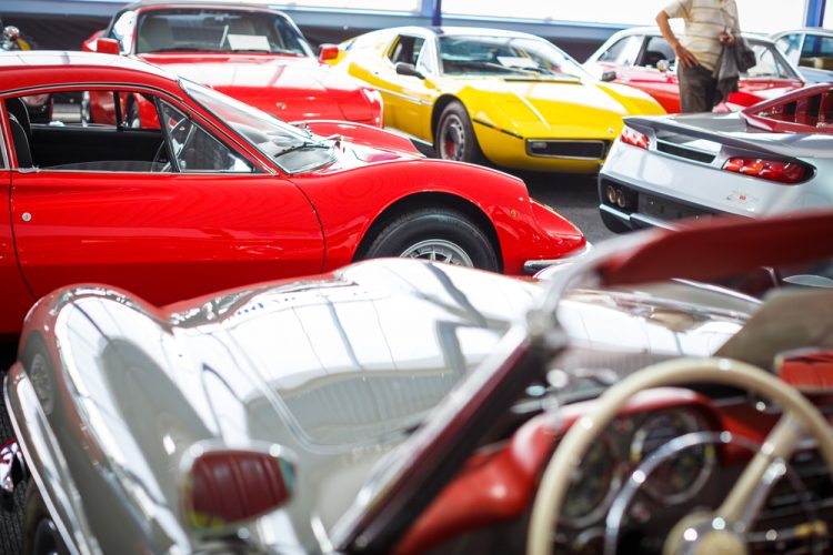 Old cars auction - People viewing cars on sale during an expensi