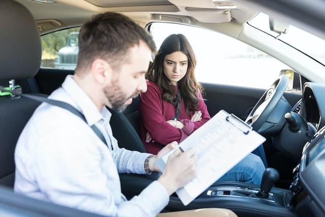 angry female learner looking at driving coach rejecting