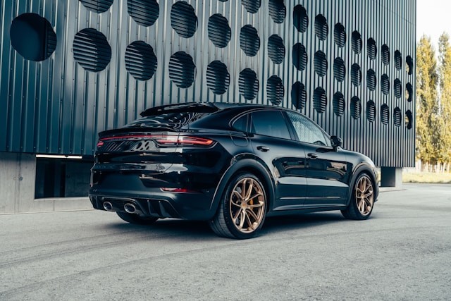 black-porsche-cayen-is-parked-in-front-of-a-building