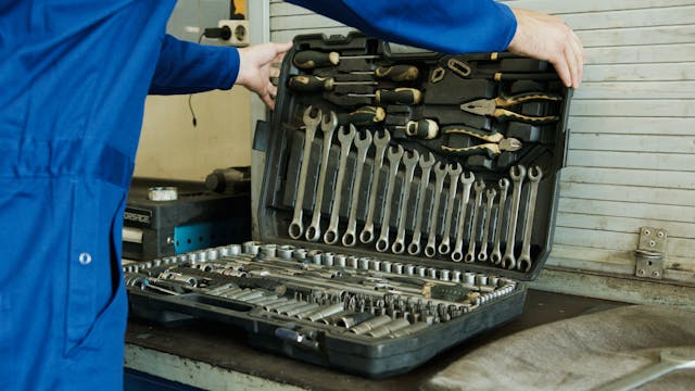 a-person-holding-a-set-of-tools-in-a-toolbox